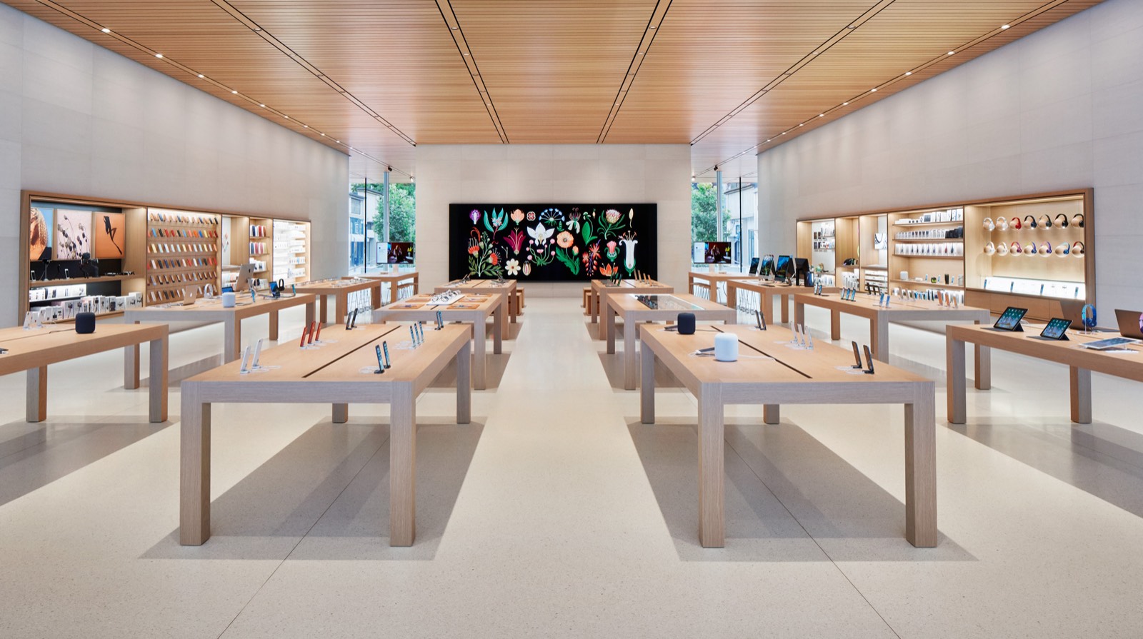 Inside an Apple Store: a minimal, gallery-like space with wooden tables and each product given room to breathe - Heyou demand generation guide